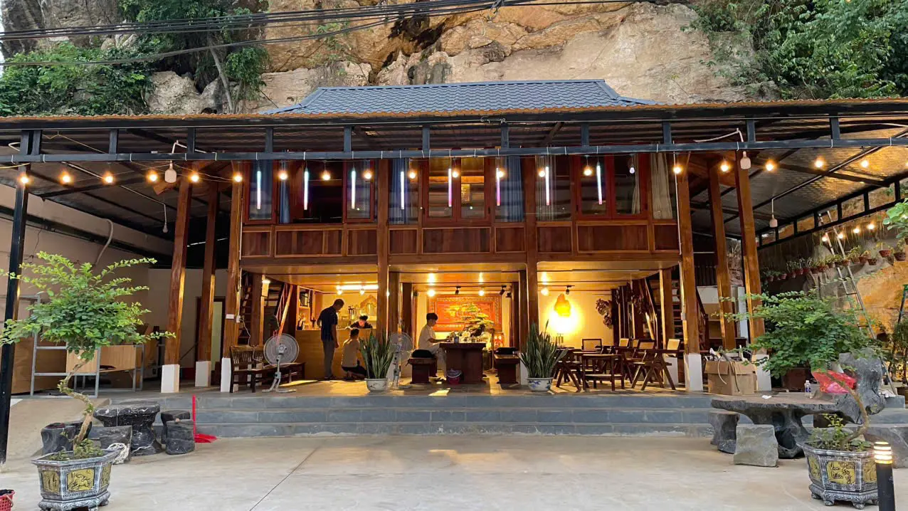 Mộc Cafe về đêm — nhà sàn gỗ dưới chân núi đá, trang trí đèn dây ấm áp